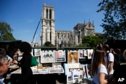 People walk near Notre Dame in Paris, April 19, 2019. The 800-year-old cathedral was devastated by fire this week.