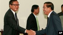 柬埔寨首相洪森（左）和反對黨領袖桑蘭西（右）在舉行議會會談之前握手。