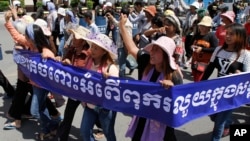 Cambodian activists shout slogans during a march toward the National Assembly, in Phnom Penh, Cambodia, Thursday, May 29, 2014. Some 300 activists on Thursday delivered petitions to the National Assembly and Anti-Corruption Unit headquarters to demand the government to stop giving land concession to private companies. The banner reads " Absolutely against the corruption in the society." (AP Photo/Heng Sinith)