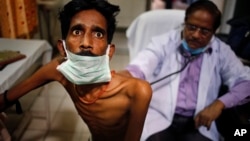 FILE - A doctor examines a tuberculosis patient in a government TB hospital in Allahabad, India, March 24, 2014. An estimated 1.8 million people die every year of the disease.