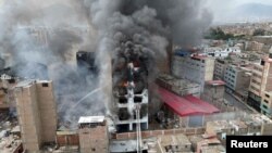 Asap tampak mengepul dari area gedung yang terbakar di Lima, Peru, pada 4 Maret 2025. (Foto: Reuters/Sebastian Castaneda)