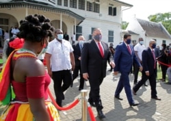 FILE - Suriname's President Chan Santokhi and U.S. Secretary of State Mike Pompeo walk together, in Paramaribo, Suriname, Sept. 17, 2020.