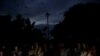 FILE - With the streetlight dark, Haitians watch the screening of a friendly soccer match between Chile and Haiti, at Jean-Jacques Dessalines square in Port-au-Prince, Haiti, June 6, 2019. 