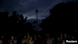 FILE - With the streetlight dark, Haitians watch the screening of a friendly soccer match between Chile and Haiti, at Jean-Jacques Dessalines square in Port-au-Prince, Haiti, June 6, 2019. 