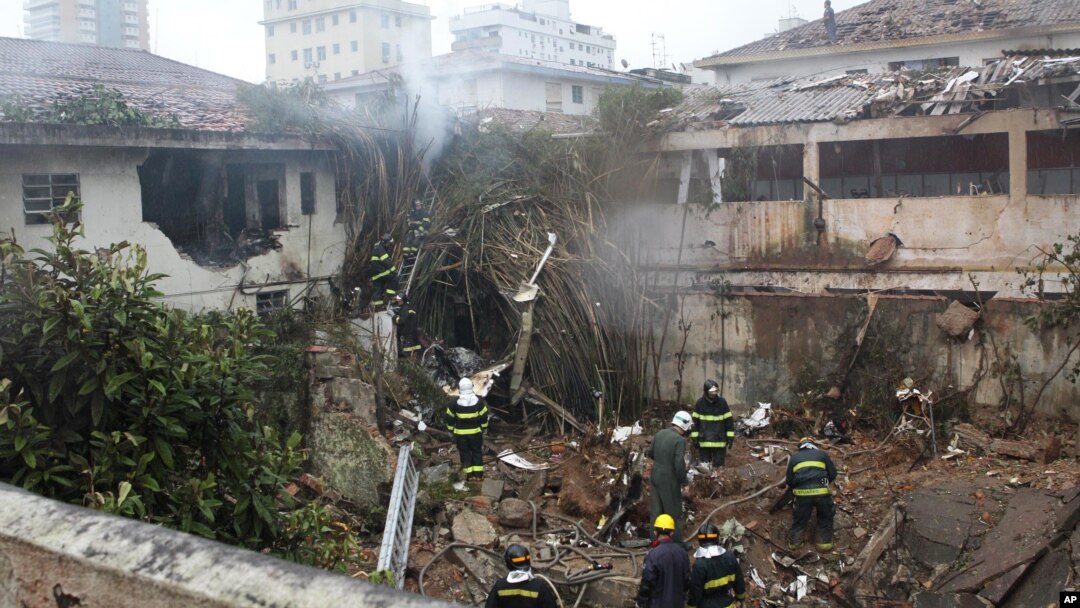 Firefighters work at the crash site of a small plane that was carrying Brazilian presidential candidate Eduardo Campos and several campaign officials, in Santos, Brazil, Aug. 13, 2014. 