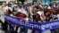 Cambodian activists shout slogans during a march toward the National Assembly, in Phnom Penh, Cambodia, Thursday, May 29, 2014. Some 300 activists on Thursday delivered petitions to the National Assembly and Anti-Corruption Unit headquarters to demand the government to stop giving land concession to private companies. The banner reads " Absolutely against the corruption in the society." (AP Photo/Heng Sinith)