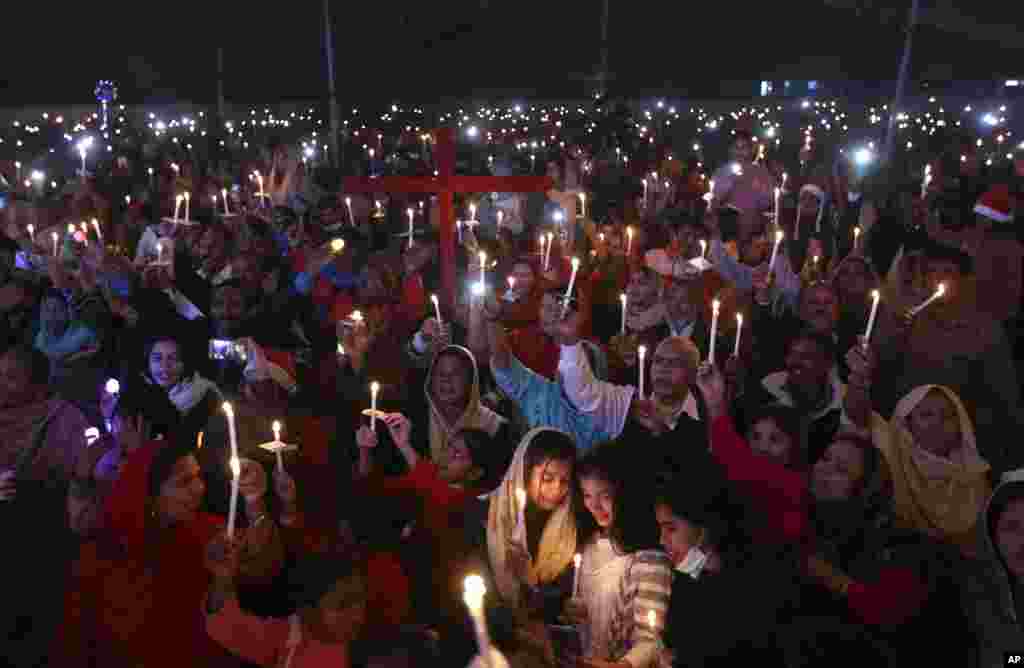 Pakistani Christians hold candles during a celebration for Christmas, in Lahore.