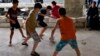 Displaced Iraqi Christian boys who fled from Islamic State militants in Mosul, play football at a mall still under construction, which is now used as a refugee camp in Irbil, Sept. 6, 2014.