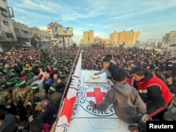 Pasukan Hamas dan warga berkumpul di sekitar kendaraan Palang Merah sebelum pembebasan sandera yang diculik, Gaza, 19 Januari 2025. (Foto: REUTERS/Dawoud Abu Alkas)