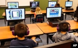 FILE - Students at a summer reading academy at Buchanan elementary school work in the computer lab in Oklahoma City.
