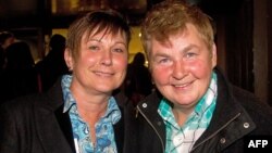 New Zealand entertainer Lynda Top (R) and her partner Donna Top join gay-rights supporters as they wait outside the parliament building in Wellington on April 17, 2013 for a place in the public gallery to see the chamber vote on a bill amending the 1955 M