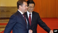 Russian President Dmitry Medvedev, left, with his Chinese counterpart Hu Jintao arrives for a welcoming ceremony at the Great Hall of the People in Beijing, 27 Sept. 2010