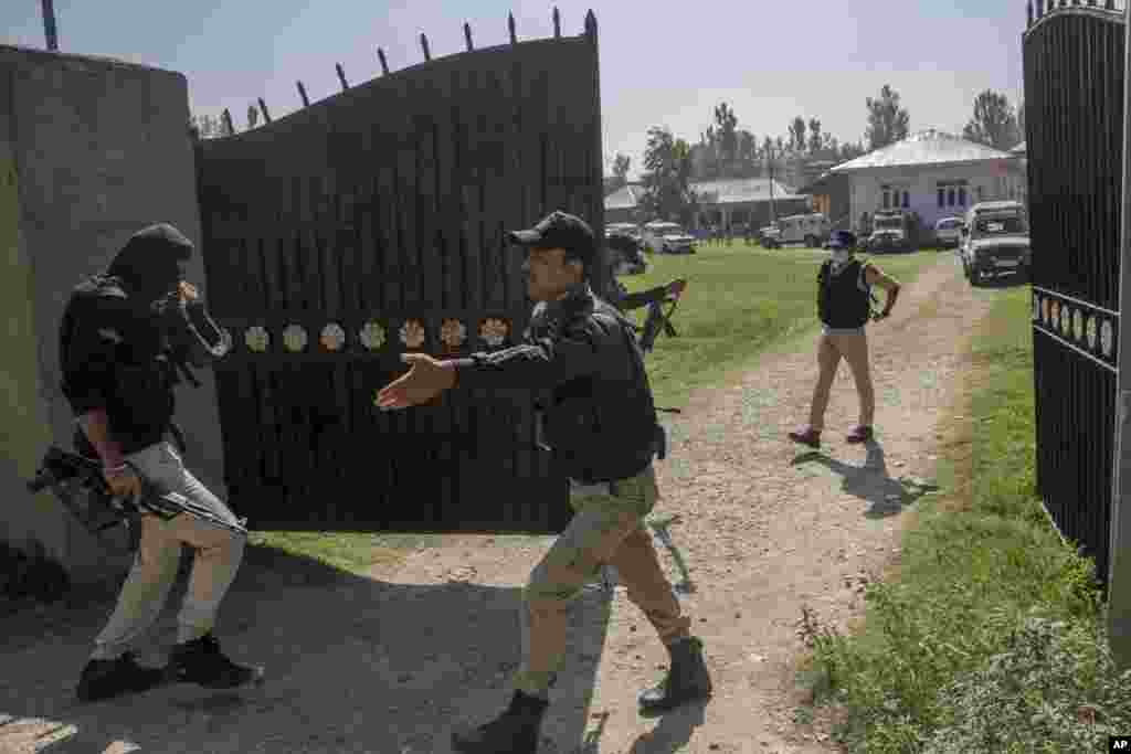 Police officers arrive at a government school where two teachers were shot dead by assailants, on the outskirts of Srinagar, India-controlled Kashmir.