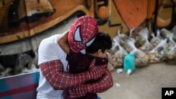 Seorang relawan yang mengenakan kostum superhero Spiderman memeluk seorang anak di wilayah Jardim Gramacho di Rio de Janeiro, Brazil, pada 30 Oktober 2021, saat program donasi makanan yang diadakan oleh organisasi nirlaba "Covid Sem Fome". (Foto: AP/Bruna Prado)