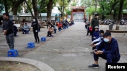 Residents wearing protective masks wait for coronavirus testing at a makeshift rapid testing center in Hanoi, Vietnam March 31, 2020.