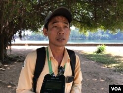 មគ្គុទេ្ទសក៍ទេសចរណ៍ភាសាអង់គ្លេសលោកសុខ សារុំ ឈរនៅផ្លូវឆ្ពោះទៅកាន់ប្រាសាទអង្គរវត្ត ថ្ងៃទី១៧ ខែមករា ឆ្នាំ២០២១។ (ហ៊ុល រស្មី/វីអូអេ)
