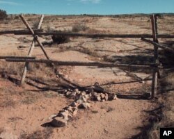 FILE - A cross of stones memorializes Matthew Shepard at the site where the University of Wyoming gay college student was beaten and left for dead in October 1998.