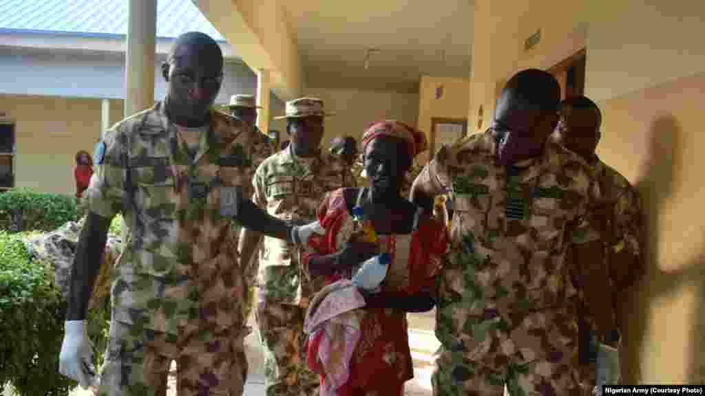 Amina Ali is escorted by Nigerian military personnel after being airlifted to Maiduguri.