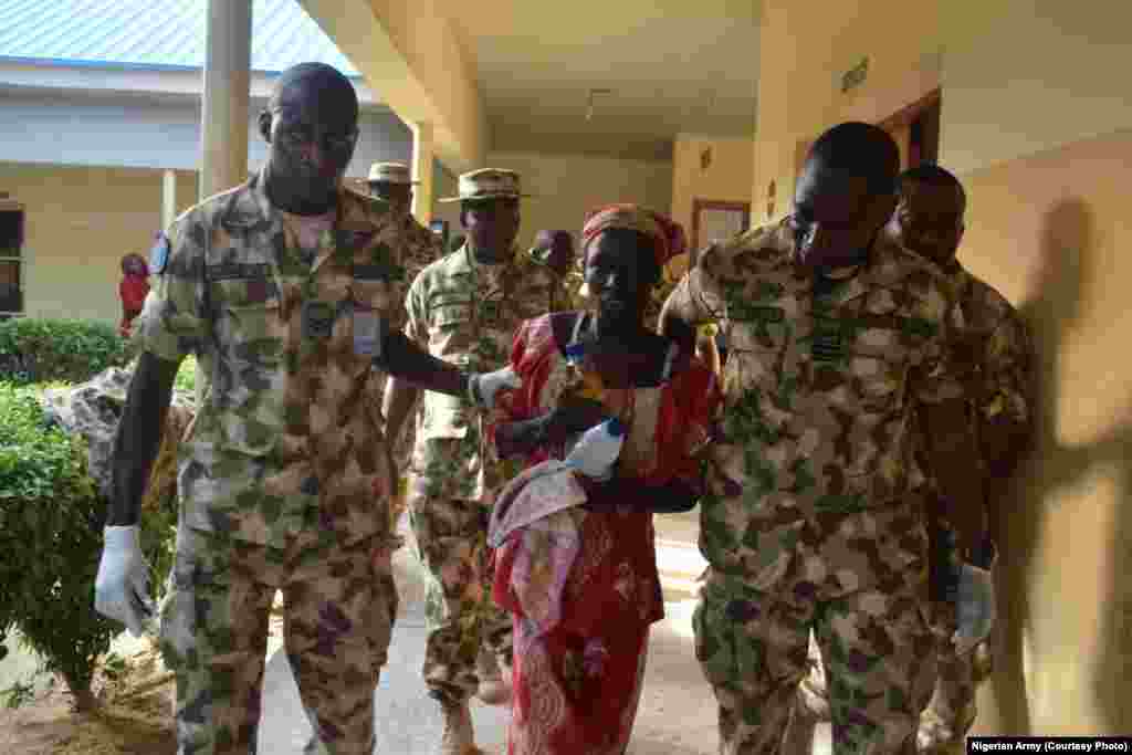 Amina Ali is escorted by Nigerian military personnel after being airlifted to Maiduguri.