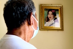 Ly Koeung, father to the 20-year-old girl who died in a road accident, looks at his daughter’s photo hanging on the wall in his home, in Kampong Chhnang province, on Oct. 24, 2021. (Kann Vicheika/VOA Khmer)