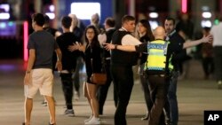 Seorang petugas kepolisian memandu warga untuk menjauh dari lokasi di sekitar London Bridge setelah insiden di London tengah tersebut, Sabtu malam, 3 Juni 2017 (foto: AP Photo/ Matt Dunham)