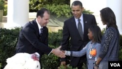 Sasha Obama saluda al presidente de la Federación Nacional de Criadores de Pavos, Yubert Envia, junto al presidente Barack Obama y Malia Obama, tras el perdón al pavo "Apple".