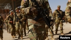 National Guard soldiers walk on the day U.S. authorities hold a ceremony to deputize the Texas National Guard to enforce Title 8 immigration laws, near the U.S.-Mexico border in El Paso, Texas, Feb. 27, 2025.