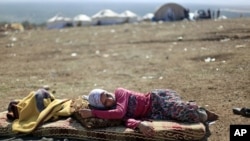 A Syrian girl who fled with her family from the violence in their village, rests at a displaced camp, in the Syrian village of Atmeh, near the Turkish border, Nov. 5, 2012.