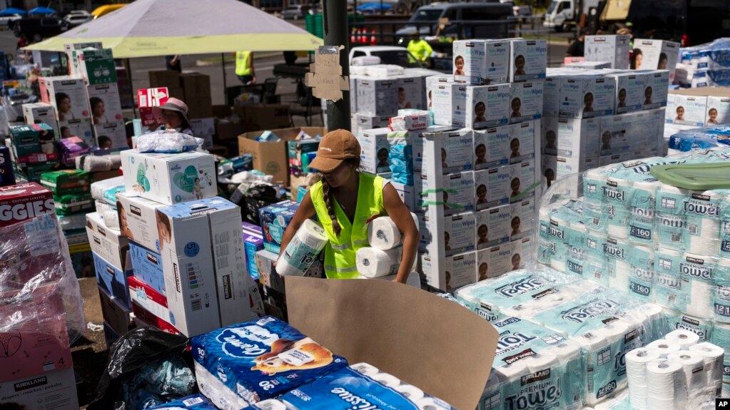 Un centro de voluntarios maneja suministros para distribuir a la población afectada por los incendios en el estacionamiento de un centro comercial de Lahaina, Hawái, el 16 de agosto de 2023.