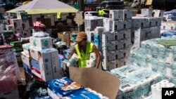 Un centro de voluntarios maneja suministros para distribuir a la población afectada por los incendios en el estacionamiento de un centro comercial de Lahaina, Hawái, el 16 de agosto de 2023.