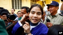 Yorm Bopha, right, a Boeung Kak lake villager, enters a court room for her hearing at the Supreme Court in Phnom Penh, Cambodia, Friday, Nov. 22, 2013.