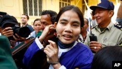 Yorm Bopha, right, a Boeung Kak lake villager, enters a court room for her hearing at the Supreme Court in Phnom Penh, Cambodia, Friday, Nov. 22, 2013. Cambodia's highest court released Bopha on bail Friday after she served more than a year in prison on charges widely condemned as trumped up to silence a government critic. The Supreme Court sent Yorm Bopha's case back to the Appeals Court for further investigation and a possible retrial. (AP Photo/Heng Sinith)