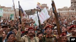 Shiite rebels, known as Houthis, hold up their weapons to protest Saudi-led airstrikes during a rally in Sanaa, Yemen, March 26, 2015. 