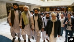 Juru bicara Taliban Mullah Abdul Ghani Baradar (ketiga dari kiri) dan para perunding Taliban (foto: dok). 