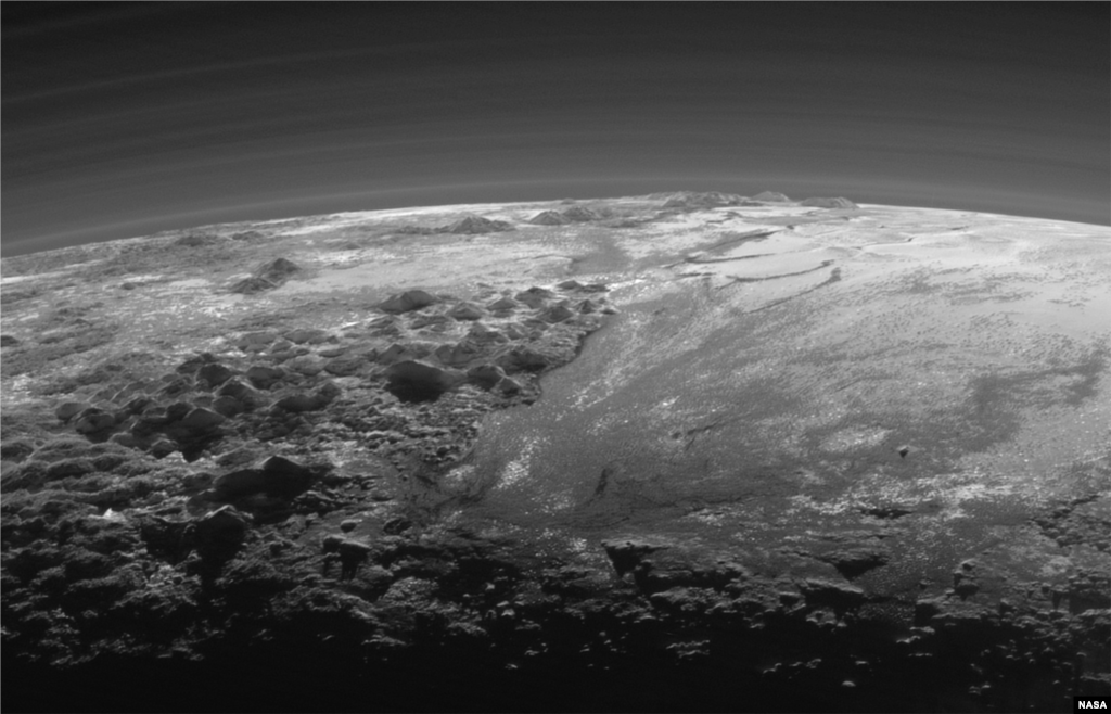 យានអវកាស New Horizons របស់អង្គការ NASA ចាប់យកទស្សនីយភាពជិតពេលព្រះអាទិត្យលិចនៅតំបន់ភ្នំប្រកបដោយទឹកកកមួយ និងវាលទំនាបទឹកកកលាតសន្ធឹងទៅជ្រោយសន្លឹមនៃភព Pluto។ 