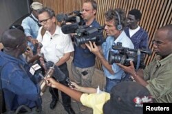 Des journalistes entourant Alhaji Jusu Jarka, une victime de la guerre sierra leonaise, devant le Tribunal spécial pour la Sierra Leone