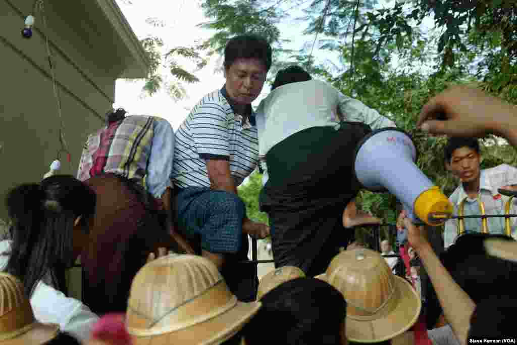 After authorities refused to open the main gate at Yangon University, demonstrators decided to climb the fence to enter the campus.