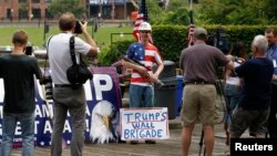 A supporter of Republican presidential candidate Donald Trump poses with a rifle while waiting for a pro-Trump rally to begin near the Republican National Convention in Cleveland, Ohio, July 18, 2016. 