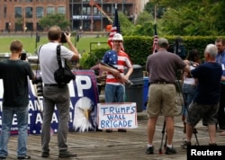 A supporter of Republican presidential candidate Donald Trump poses with a rifle while waiting for a pro-Trump rally to begin near the Republican National Convention in Cleveland, Ohio, July 18, 2016.