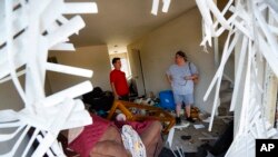 Shaun Vaine, kiri, dan Michele Thrash, kanan, berdiri di rumahnya yang hancur di komplek apartemen Ruver’s Edge, 28 Mei 2019 di Dayton, Ohio, sehari setelah puting beliung melanda kota tersebut (foto: AP Photo/John Minchillo)