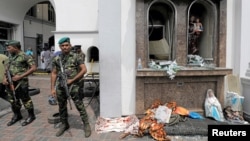 FILE - Sri Lankan military officials stand guard in front of St. Anthony's Shrine after an explosion in Colombo, Sri Lanka, April 21, 2019. 