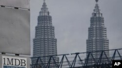 Logo 1MDB (1 Malaysia Development Berhad) di dekat menera kembar Petronas Twin Towers di kawasan Tun Razak Exchange, Kuala Lumpur, Malaysia, 8 JUli 2015. (Foto: dok).