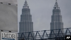 Logo 1MDB (1 Malaysia Development Berhad) di dekat Menara Kembar Petronas di lokasi pengembangan utama, Tun Razak Exchange di Kuala Lumpur, Malaysia, 8 Juli 2015. (AP/Joshua Paul)