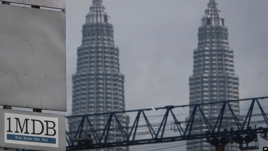 Logo 1MDB (1 Malaysia Development Berhad) di seberang Menara Kembar Petronas di lokasi proyek pembangunan, Tun Razak Exchange di Kuala Lumpur, Malaysia, 8 Juli 2015.