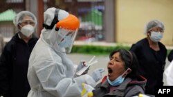 Personal de la salud boliviano es visto tomando una prueba de PCR para detectar COVID-19, afuera del Hospital de Clínicas en La Paz, el 4 de enero de 2021.