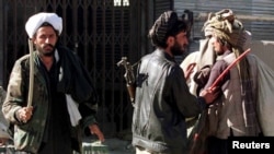 FILE - Islamic Taliban militia, trying to enforce a rigid interpretation of Shariah law, use a whip to force locals to attend the Friday prayer at the Pole-Kheshti mosque in central Kabul, Nov. 8, 1996. 