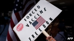FILE - An anti-vaccine protester holds a sign during a rally outside Houston Methodist Hospital in Houston, Texas, June 26, 2021.