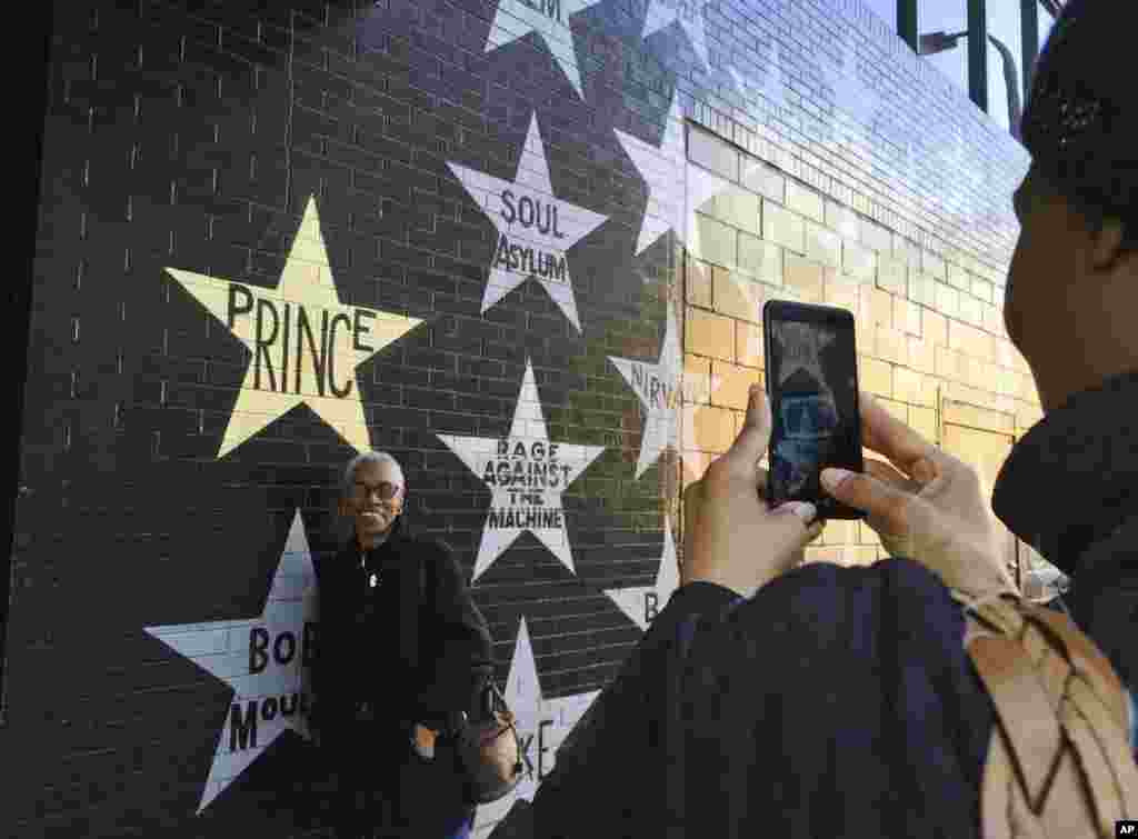 Fans take photos outside First Avenue nightclub in Minneapolis, Minnesota. People stopped by the star-painted wall Friday to remember and pay respects to Prince on the one-year anniversary of his death from an accidental fentanyl overdose.