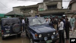 Pakistani media follow a senior police officer at outside the house of a abducted American citizen in Lahore, Pakistan, August 13, 2011