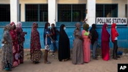 People queue to vote for the presidential election to be held on December 4, 2021 in Bacau, The Gambia, Gambia.  The people of The Gambia vote in a historic election that will not feature for the first time former dictator Yahya Jammeh, who ruled for 22 years.  ,